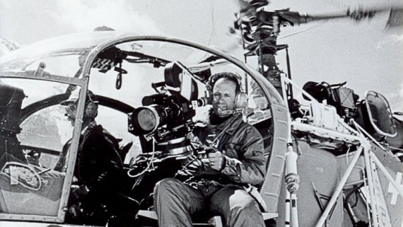 In den 80er Jahren wurde die ISPO international immer beliebter. Schwarz weiß Bild von Mann mit Kamera in Helikopter.