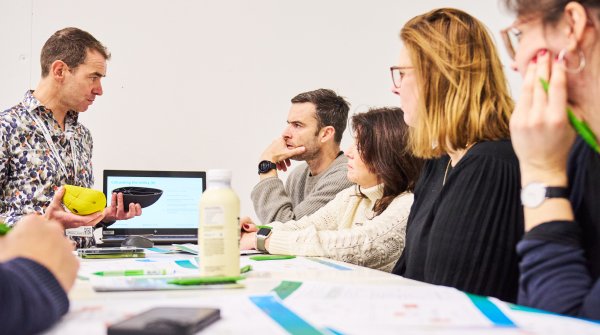 People sit around a table and talk about a product.